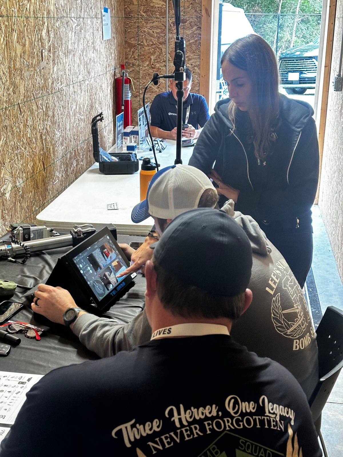 Bomb technician working a device with digital x-ray while an evaluator observes